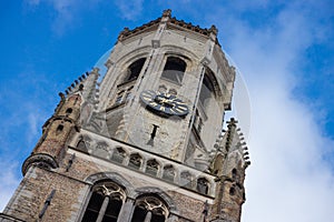 Looking Up View Of The Medieval Bell Tower Belfort Belfry With Tower Clock And Cloudy Sky. Medieval Famous Landmark Tower Bel photo