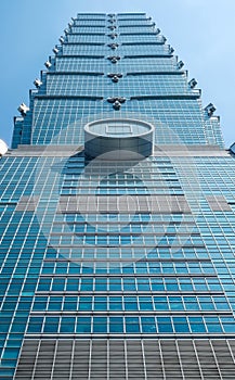 Looking up view of Taipei 101, the landmark of Taiwan, reflect blue sky and sun lights