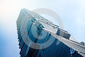 Looking up view of Taipei 101, the landmark of Taiwan, reflect blue sky and sun lights