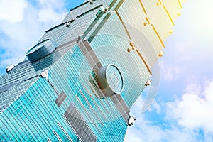 Looking up view of Taipei 101, the landmark of Taiwan, reflect blue sky and sun lights