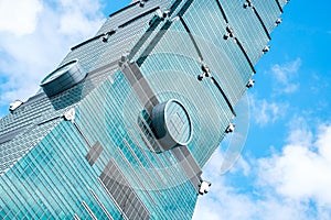 Looking up view of Taipei 101, the landmark of Taiwan, reflect blue sky and sun lights