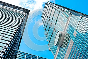 Looking up view of Taipei 101, the landmark of Taiwan, reflect blue sky and sun lights