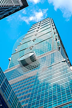 Looking up view of Taipei 101, the landmark of Taiwan, reflect blue sky and sun lights
