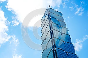 Looking up view of Taipei 101, the landmark of Taiwan, reflect blue sky and sun lights