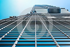 Looking up view of Taipei 101, the landmark of Taiwan, reflect blue sky and sun lights