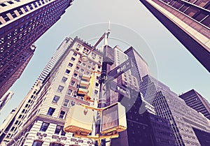 Looking up at Wall Street and Water Street signs, color toning applied, New York City, USA