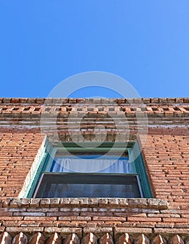Looking up at a window in an old brick building.