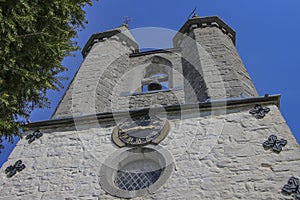 Looking upwards against a blue sky at a double church spire