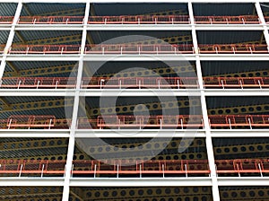 Looking upwards view of large modern commercial building under construction with steel beams and girders with orange safety fences