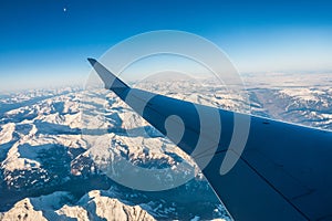 Looking through the window aircraft during flight a snow covered Italian and Osterreich