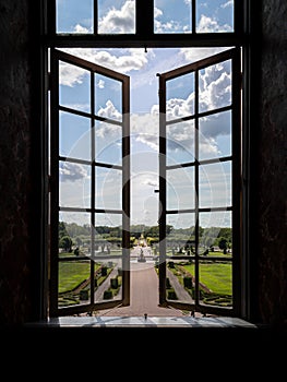 Looking through a window in Drottningholm castle out over the castle garden in summertime