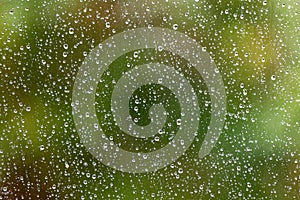 Looking through a window with rain drops on the outside and a shallow depth of field