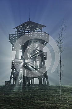 Lookout tower in fog, beams of light