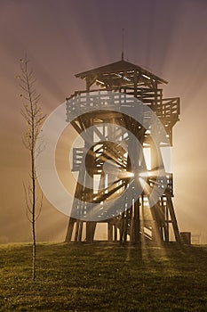 Lookout tower in fog, beams of light