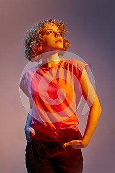 Looks composed. Portrait of stylish beautiful young redheaded woman posing isolated on dark studio background in neon