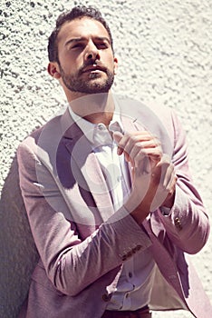 He looks damn good. a well-dressed young man posing outside.