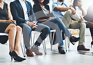 Looks like everyone is here. Low shot of a group of unrecognizable businesspeople sitting in the conference room during