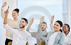 Looks like they have questions. a young and diverse group of businesspeople raising their hands during a seminar in the