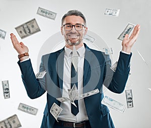 Looks like he hit the jackpot. Studio portrait of a mature businessman surrounded by falling money.