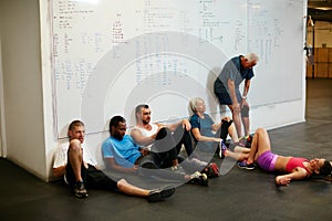 Looks like it was a good session. a group of people chilling at the gym after a workout.