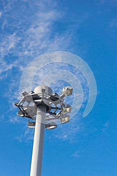 Lookup close up view of high mast lighting pole lights tower with antenna under cloud blue sky in Japan