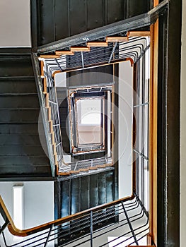 Lookup to spiral rectangle metal staircase with window