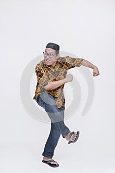 A looney middle aged about to make a getaway a comical fashion. Escaping by running in a funny way. Wearing a batik shirt and