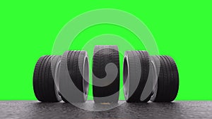 Loop four car wheels rolling on wet asphalt on a green background