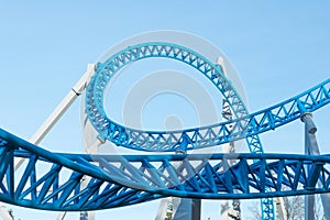 Loop and turn on a blue roller coaster in an amusement park.