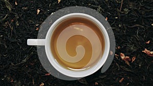 Loopable Cinemagraph of Cup of Green Tea among Dry Tea Leaves. Top View