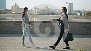 Looping of businesspeople man and woman walking outdoors shaking hands greeting