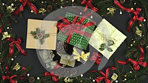 Looping overhead gift boxes on dark gray background with decoration frame of pine cones,red and gold ribbons,blinking