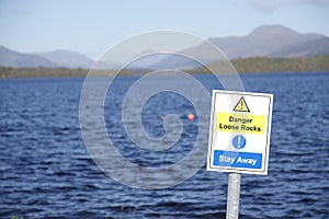 Loose rocks danger sign at coastal lake stay away message