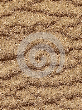 Loose sand under the influence of the wind on the seashore, background, vertical position