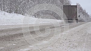 Loose Snow Flies from under Truck Wheels on the Highway