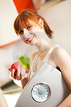 Loosing weight - woman with scale and apple