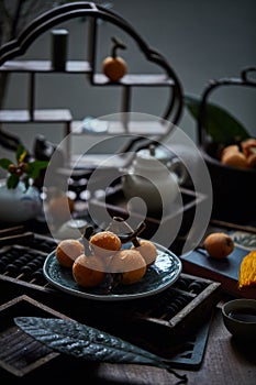 Loquat fruit on the table in architectural interior with oriental charm(Eriobotrya japonica), dark environment