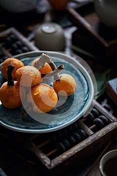 Loquat fruit on the table in architectural interior with oriental charm(Eriobotrya japonica), dark environment