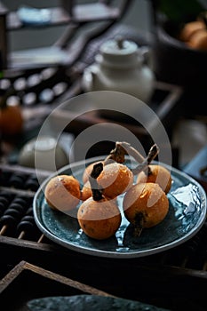 Loquat fruit on the table in architectural interior with oriental charm(Eriobotrya japonica), dark environment