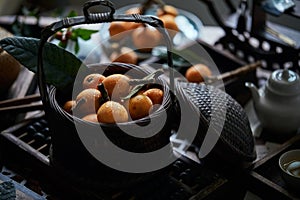 Loquat fruit on the table in architectural interior with oriental charm(Eriobotrya japonica), dark environment