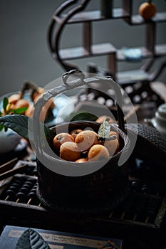 Loquat fruit on the table in architectural interior with oriental charm(Eriobotrya japonica), dark environment