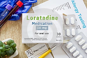 Loratadine medication or allergy drug concept photo. On  doctor table is pack with words `Loratadine medication` and pills for tre