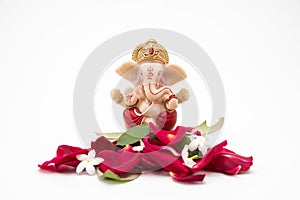 Lord Ganesha Idol with rose petals on white background, ganesh chaurthi, ganesh pooja