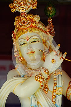 Lord Krishna statue close up image with holding a flute