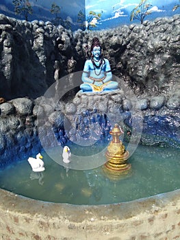 Lord Shankar is enthralled, water is filled around him, the duck is swimming in the water.