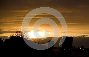 Lorries on a road at sunset