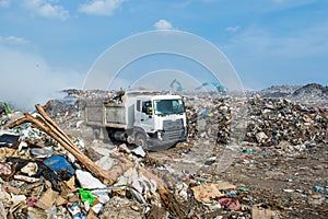 Lorry at the huge garbage dump full of smoke, litter, plastic bottles,rubbish and trash at the Thilafushi local tropical island