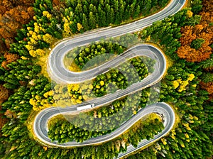 Lorry winding up its way on a curvy road through autumn colored