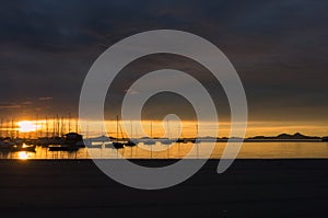 Los Alcazares, Spain. The seaport during an amazing sunrise with sun reflection on water