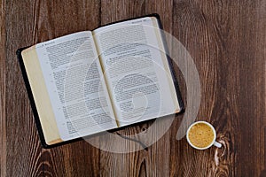 Open Bible morning readings on a table top with coffee cup